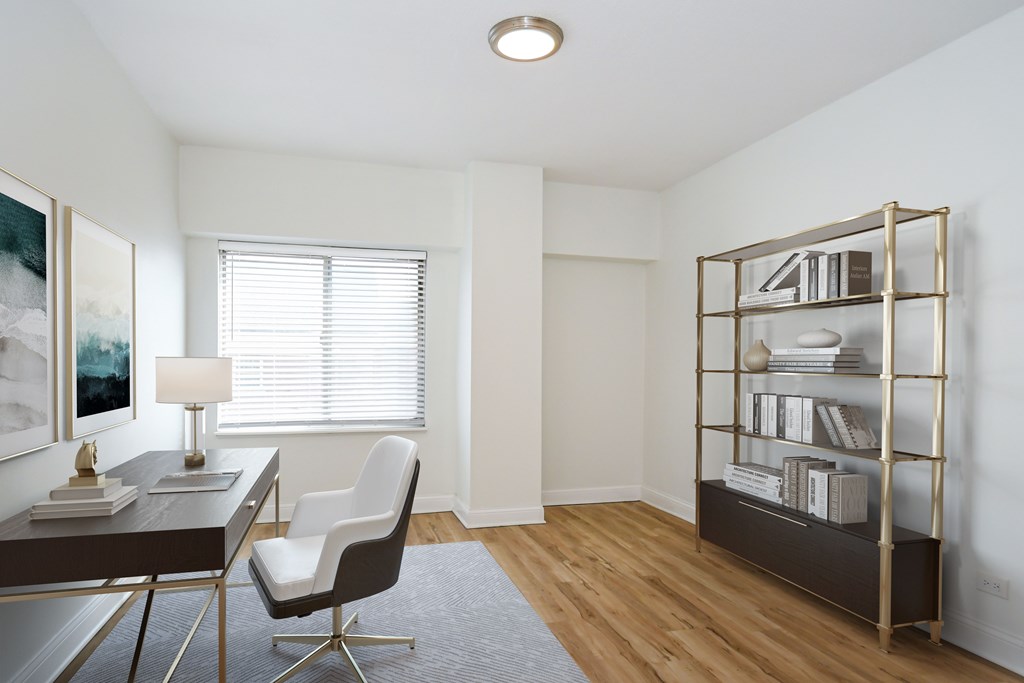 A room with a desk, chair, and bookshelf.