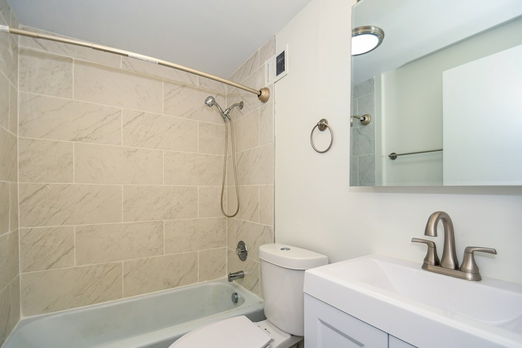 A bathroom with a toilet, sink, and shower.