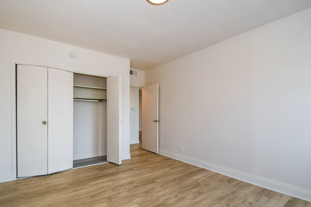 A room with a white wall and a wooden floor.