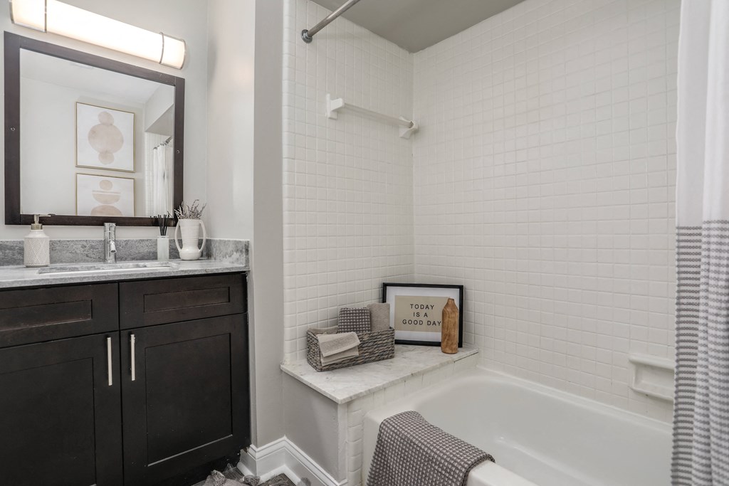 a bathroom with a tub and a sink and a mirror