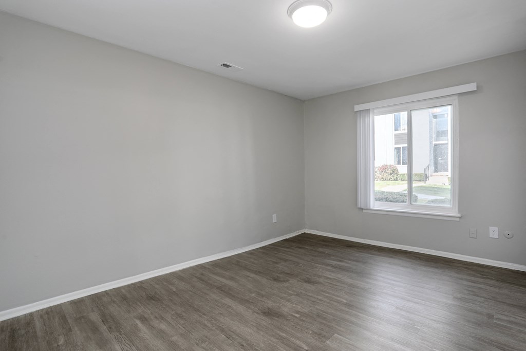 an empty room with white walls and a window