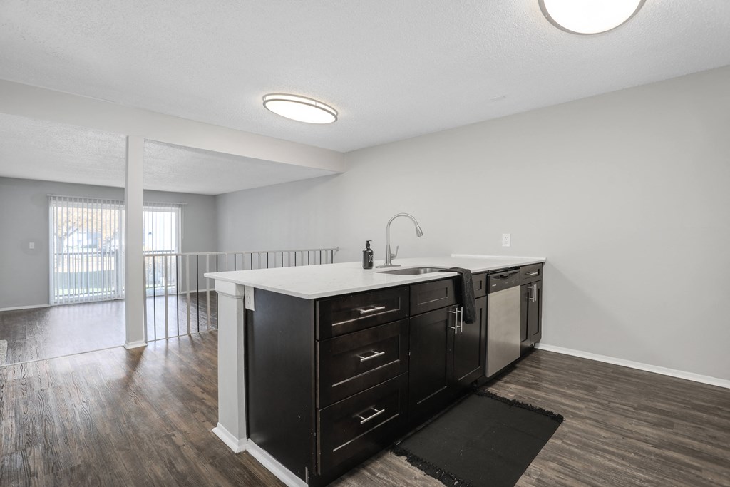 a kitchen with a sink and a counter top in a renovated apartment