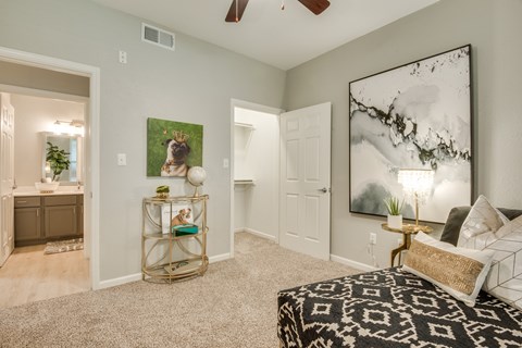 A bedroom with a large bed and a painting on the wall.