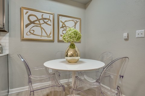 A dining room with a white table and chairs.