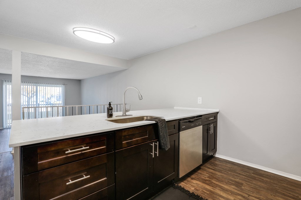 an empty kitchen with a large counter top and a sink