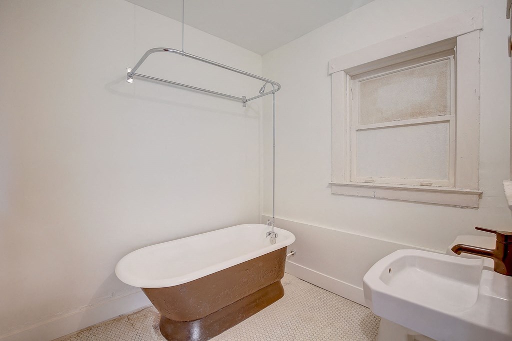 a bathroom with a tub and a sink and a window