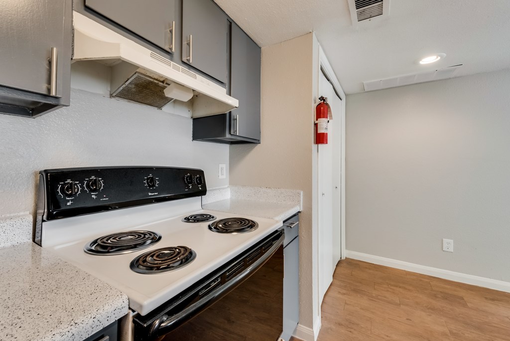 A white stove top oven with four burners and a white counter top.