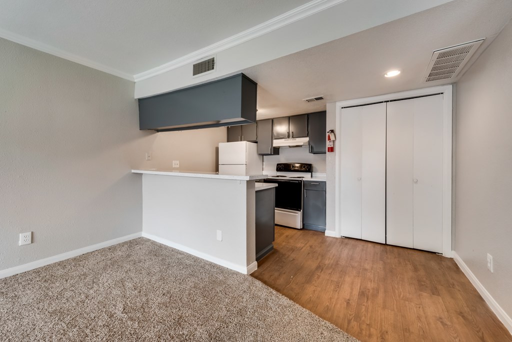 A kitchen area with a white countertop and a black hood.