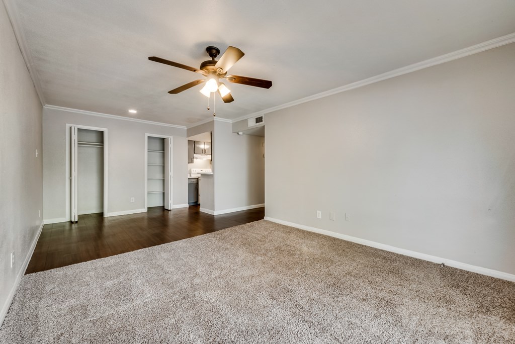 A room with a ceiling fan and carpeted floor.