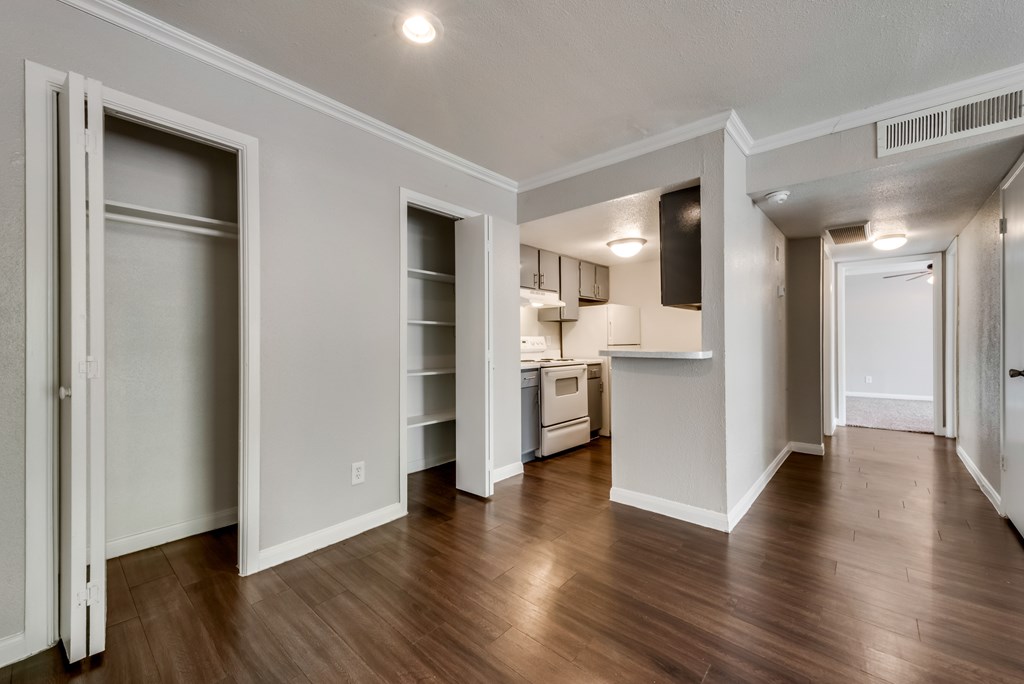 A kitchen area with a refrigerator, sink, and cabinets.