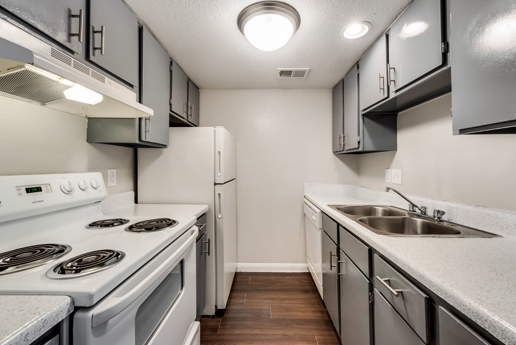 A kitchen with a white stove top oven and a white refrigerator.