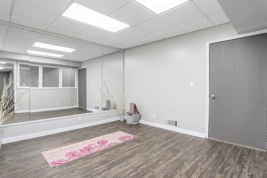 an empty room with a rug in the middle of the floor