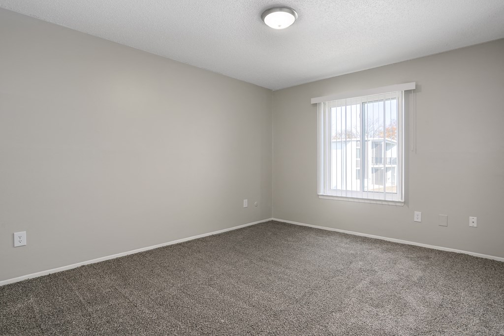 an empty room with carpet and a window
