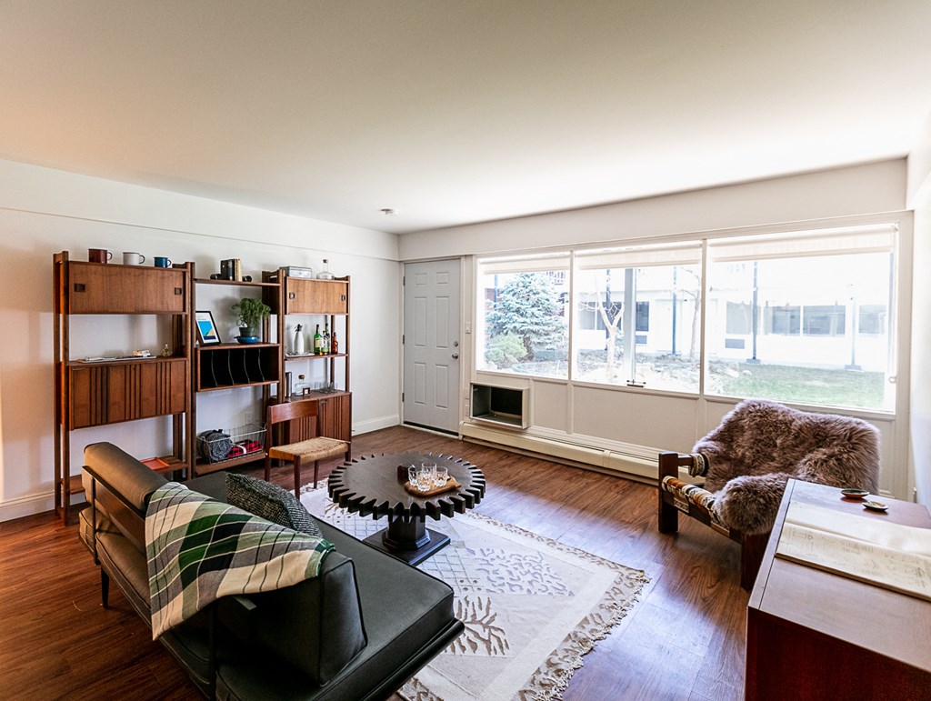 a living room with a leather couch and chair and a large window with a view of the