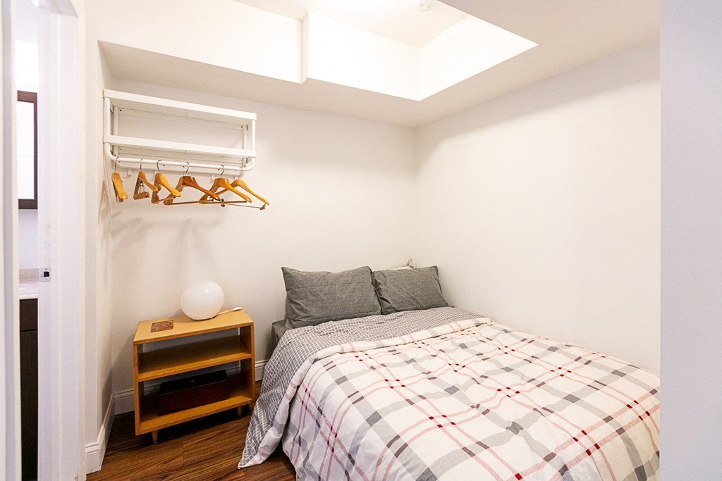 a small bedroom with a bed and a nightstand