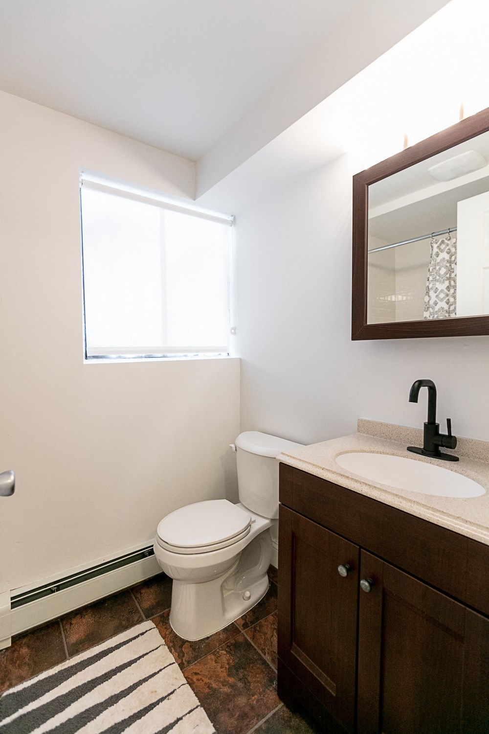 a bathroom with a toilet sink and mirror