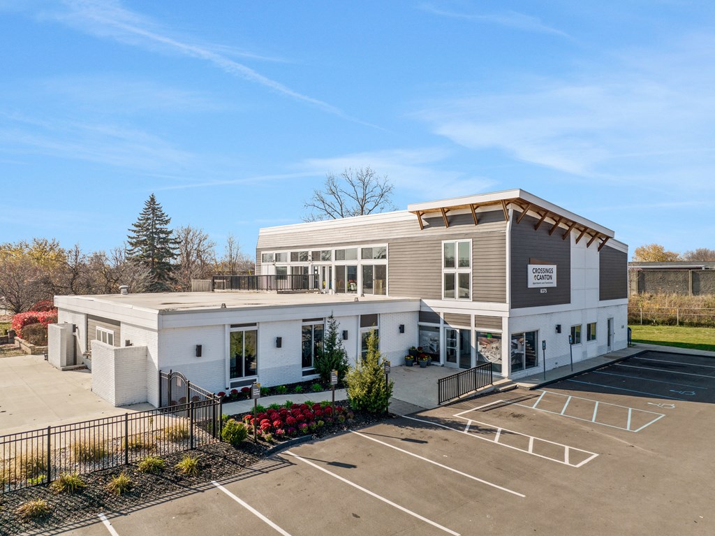 a white and brown building with a parking lot