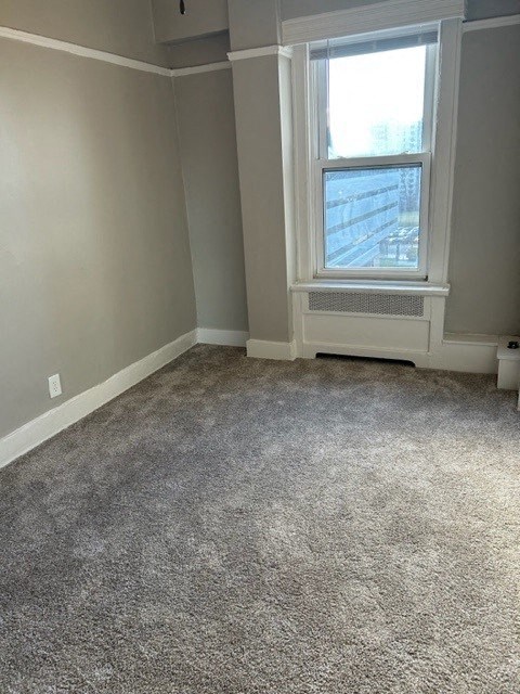 an empty room with a window and a carpet floor