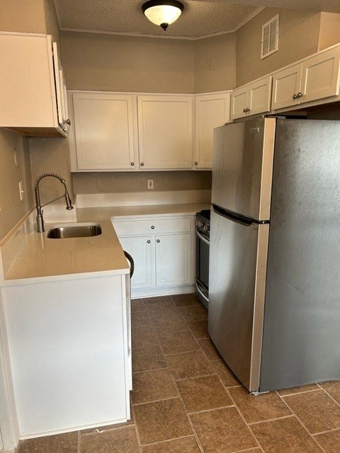a kitchen with a stainless steel refrigerator and a sink