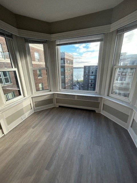 a living room with a large window and wooden floors