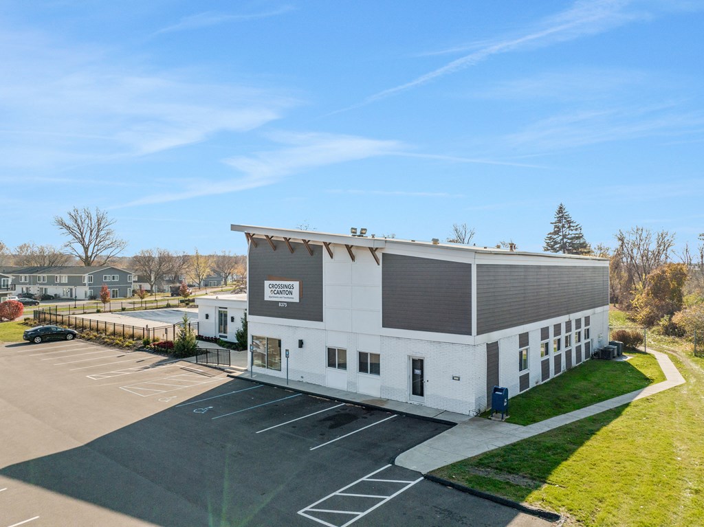 a white building with a sign on it in a parking lot