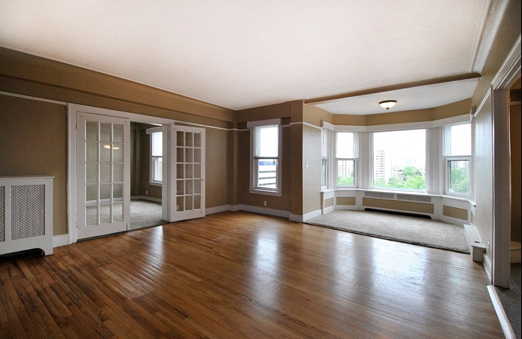 Living room with reading nook with large windows and double doors.