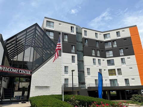 A modern building with a black and white facade and a welcome center in front.