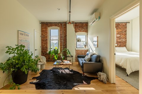 a bedroom with a bed and a living room with a couch and a table