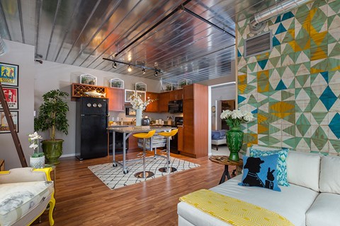 a living room with a kitchen and a yellow couch