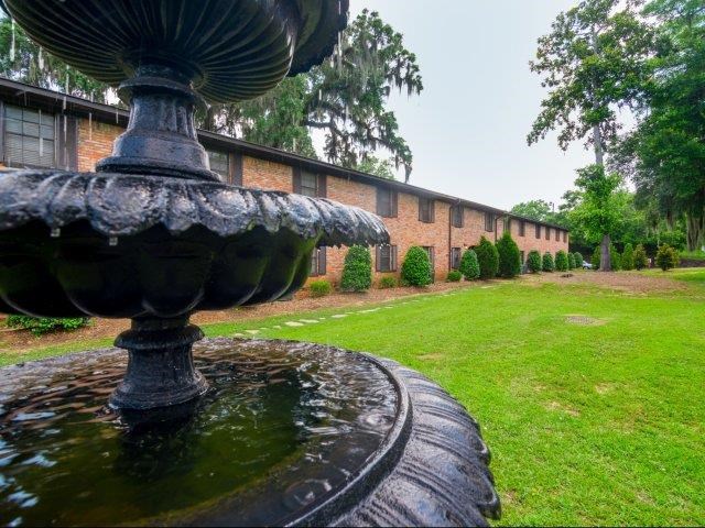a fountain in a yard in front of a building