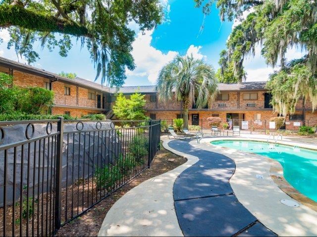 a swimming pool is next to a wrought iron fence