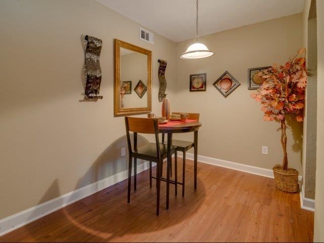 a dining room with a table and chairs and a mirror