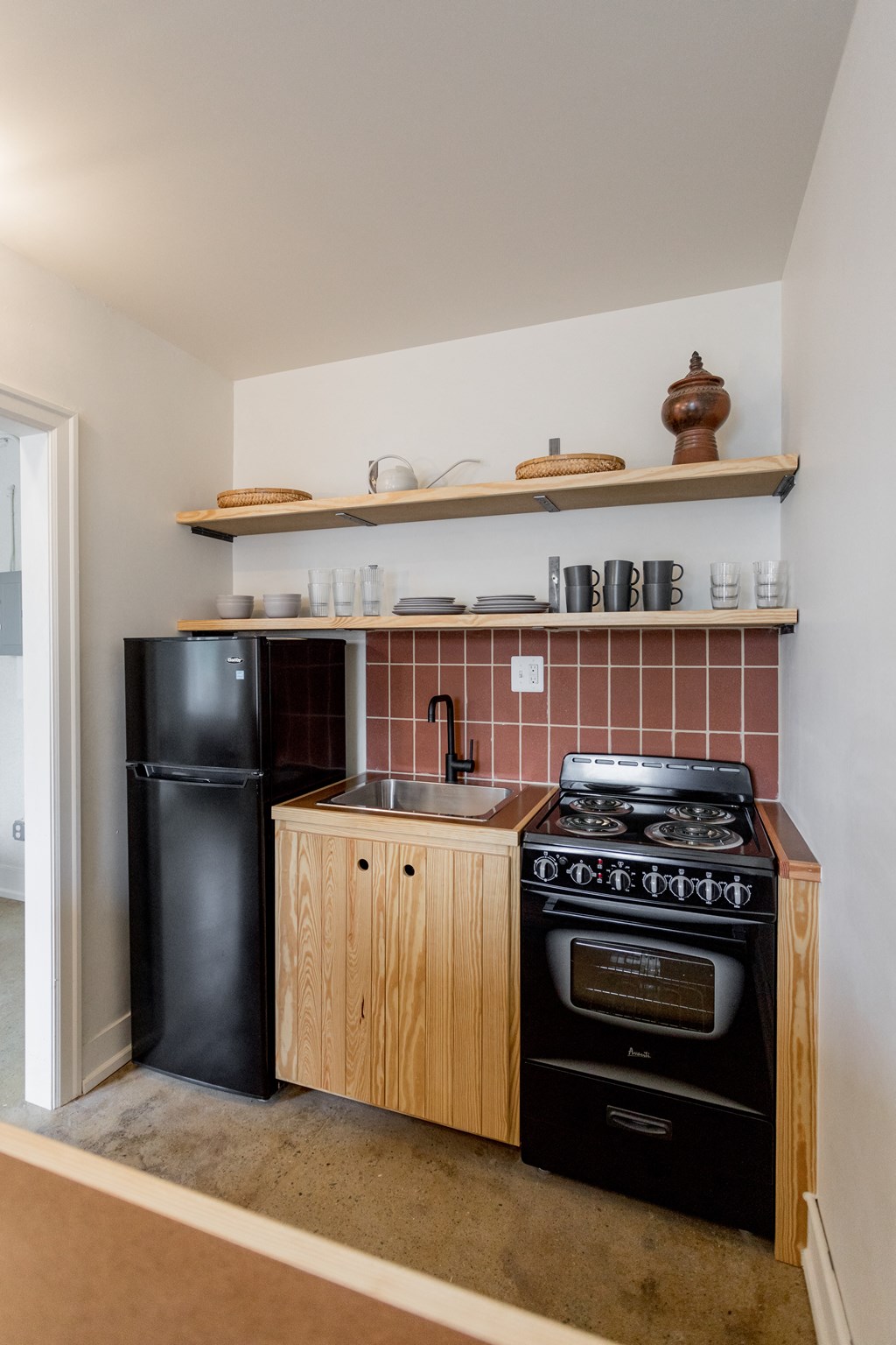 a small kitchen with black appliances and wooden cabinets