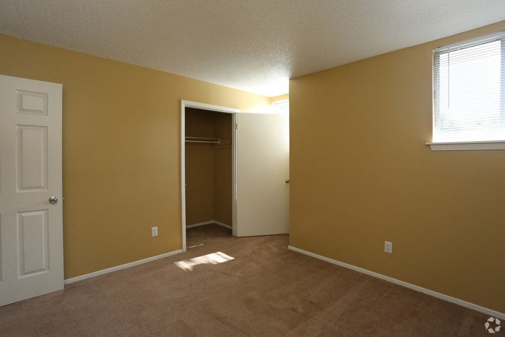 Bedroom with tan carpeting and pain and a large closet.