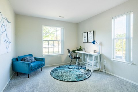 a home office with a blue chair and a white desk