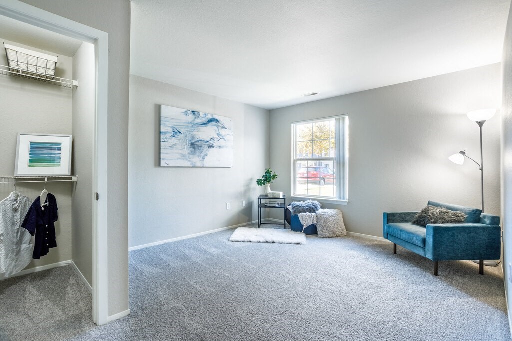 a living room with a couch and a chair and a window
