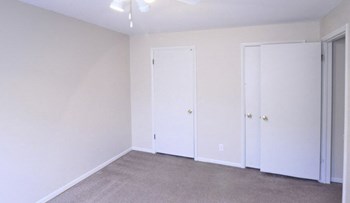 Bedroom with two closets, white walls, and grey carpet. - Photo Gallery 6