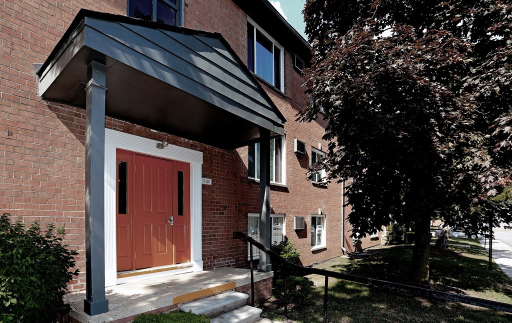 a red door on the side of a brick building