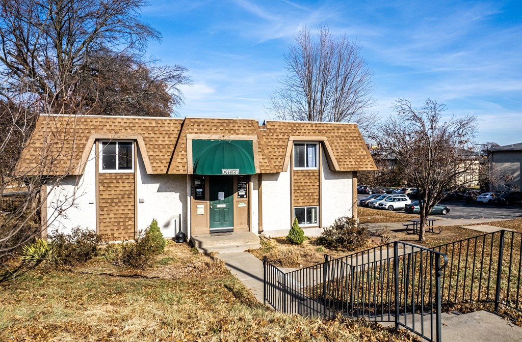 a small house with a green awning on the side of a street