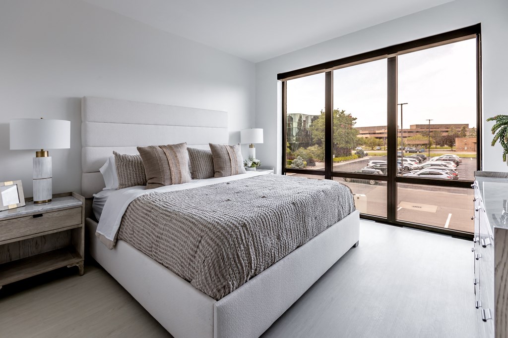 a bedroom with a bed and a large window