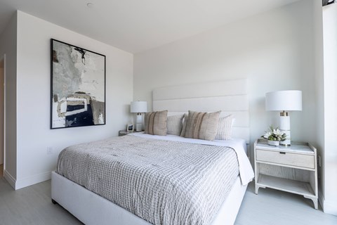 a bedroom with a large bed and a painting on the wall