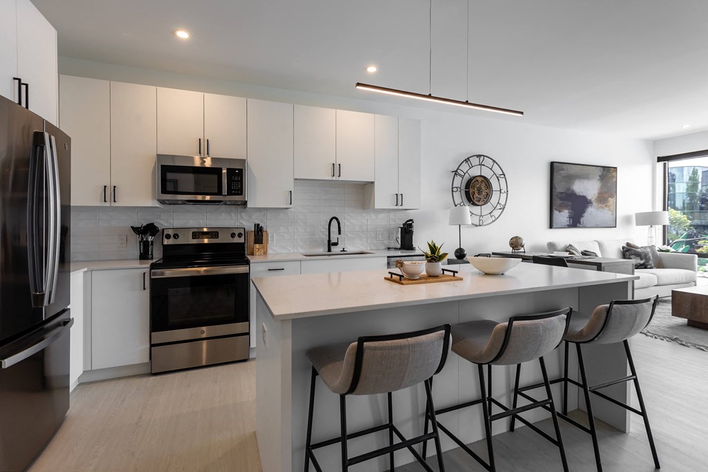 an open kitchen with a large island with four stools