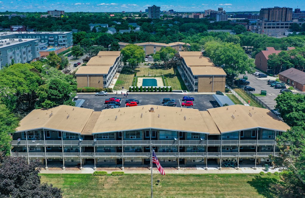 an aerial view of a building with a brown roof and a parking lot