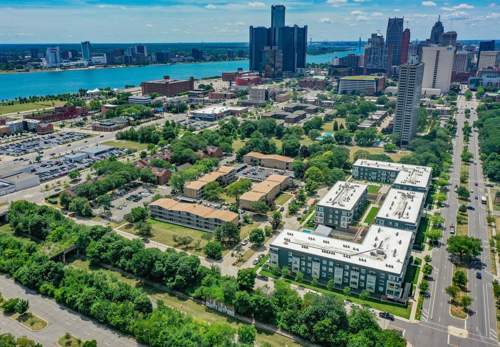 an aerial view of a city with buildings and trees and a river