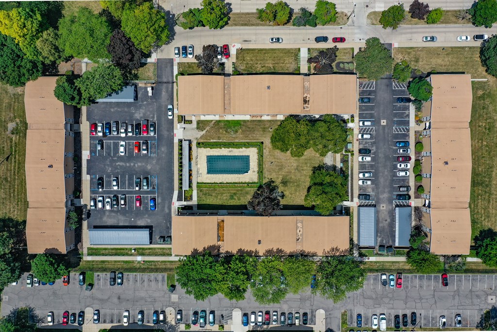 an aerial view of the parking lot of a building with trees