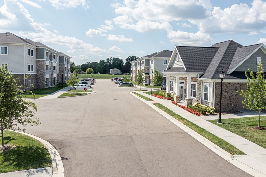 Photo of drivway to apartment homes in the community, clubhouse to thr right, apartment homes to the left.
