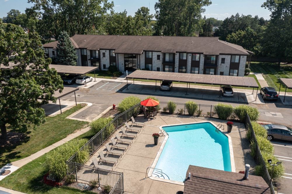 an aerial view of a swimming pool in front of a building