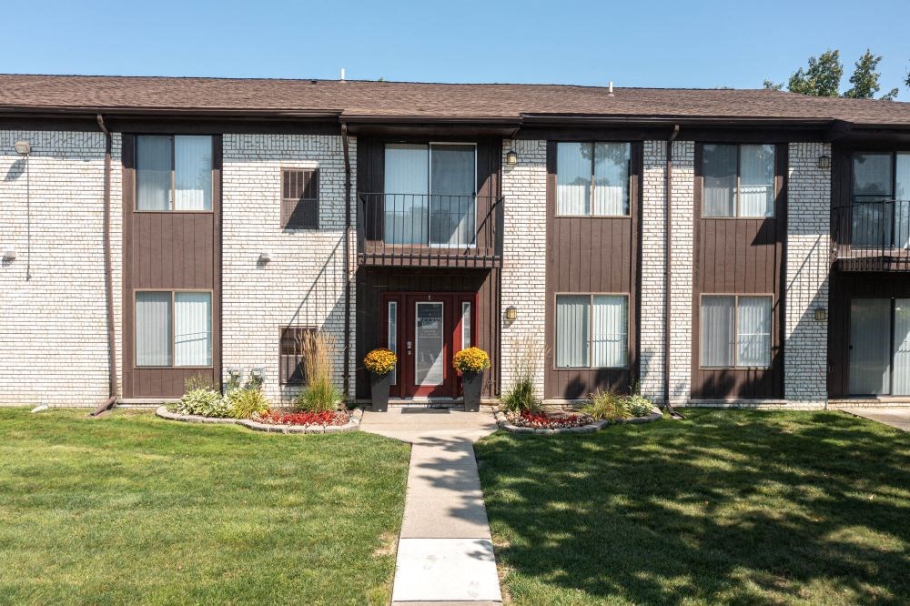 a brick apartment building with a red door
