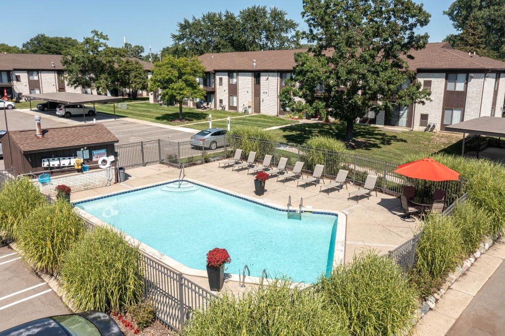 an aerial view of a swimming pool in front of an apartment building
