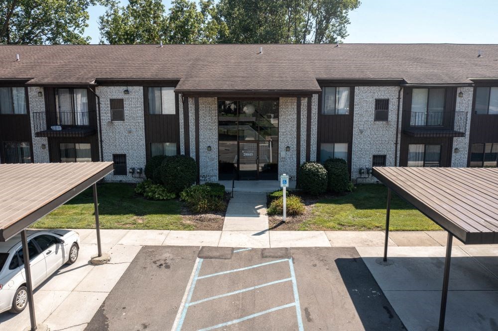an empty parking lot in front of an apartment building
